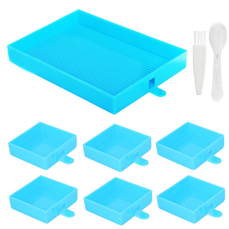 Blue diamond painting tray organizer set with 1 large tray and 6 color-sorting trays, plus spoon and brush for diamond art projects.