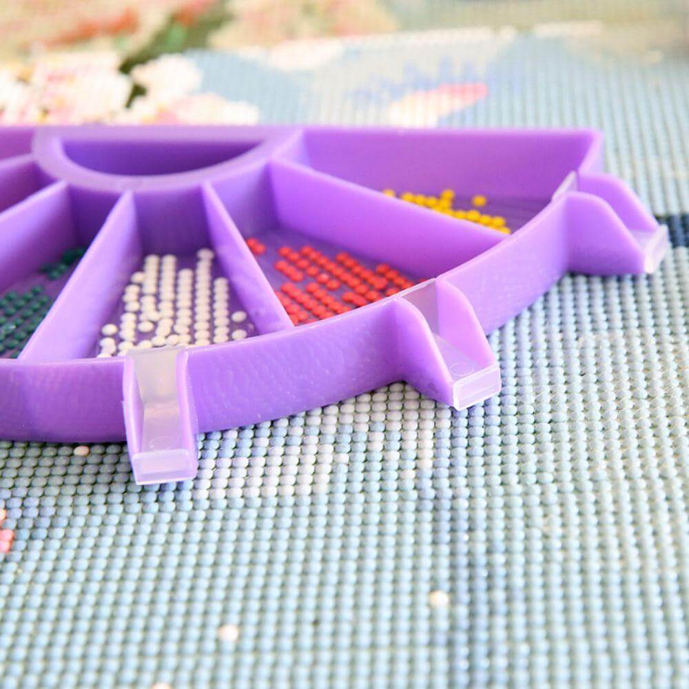 Hand using purple diamond painting tray to pour resin drills ,with white Protective Covers,Use 6 colors of diamonds at the same time.