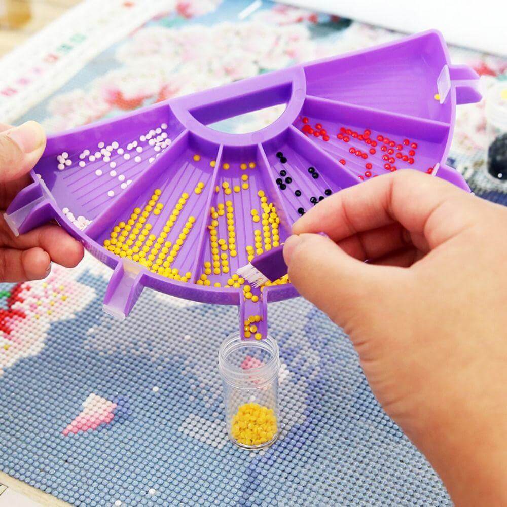 Diamond painting tray being used to pour extra drills.Use a small brush to pour the extra diamonds back into the storage