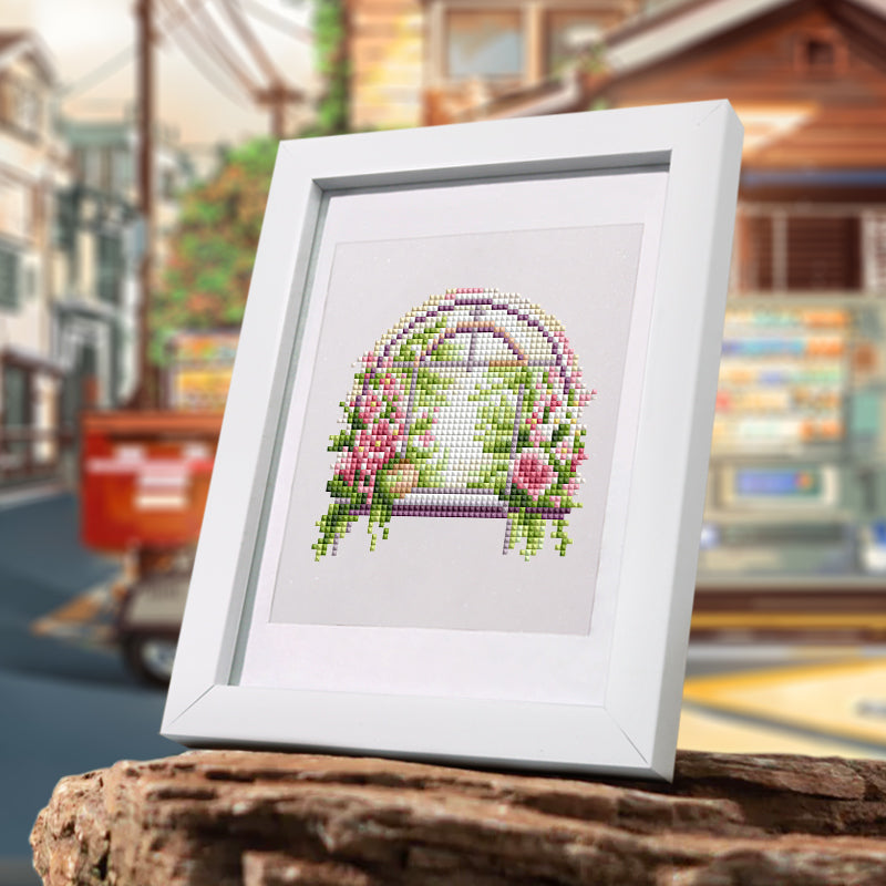 Framed floral window diamond painting kit displayed in an outdoor café-style window setting