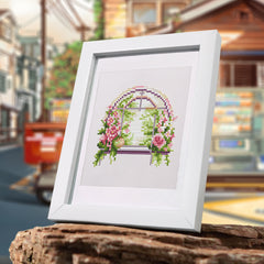 Framed floral window diamond painting kit displayed in an outdoor café-style window setting