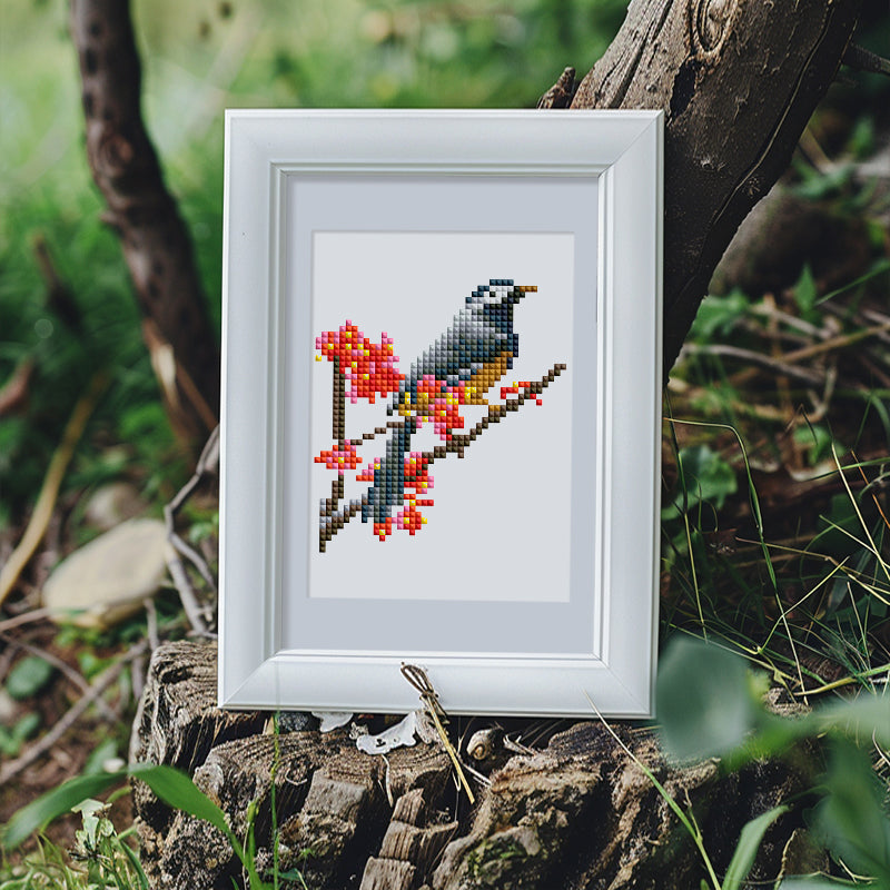 Bird diamond painting displayed outdoors with natural light and wooden frame.