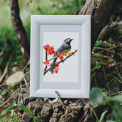 Bird diamond painting displayed outdoors with natural light and wooden frame.