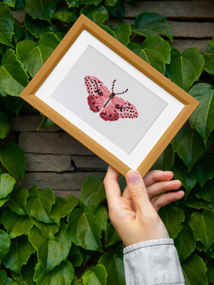 Hand holding pink butterfly mini diamond art in wooden frame – perfect for mindful crafting and personal expression.