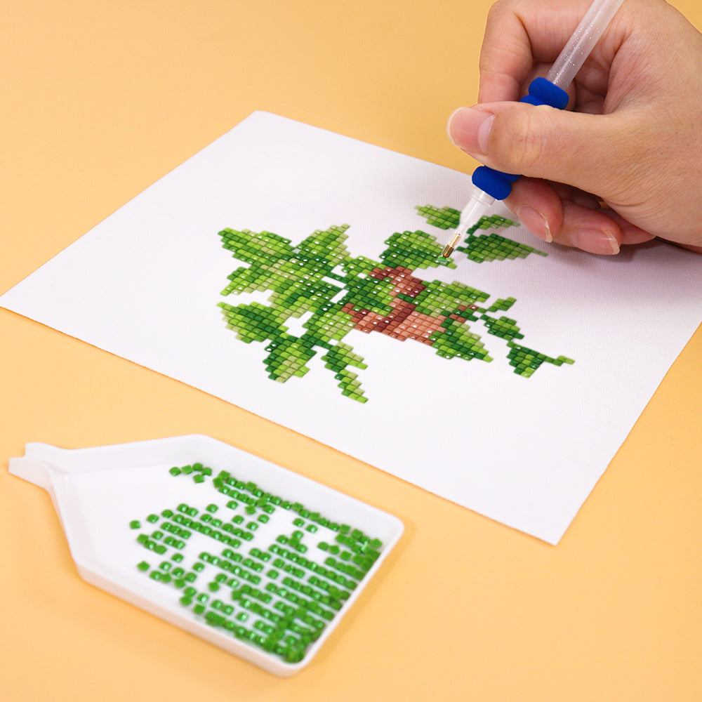 Hands placing colorful drills on a green leafy canvas—relaxing indoor craft for stress relief.