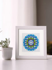 Blue and yellow mandala art framed on a table next to indoor plant – zen and aesthetic home corner.