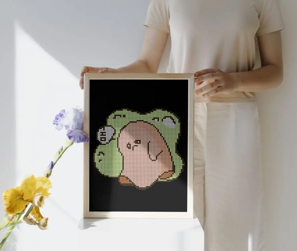Framed mini cute Sad Ghost diamond painting, displayed as wall art. Pastel green-beige tones, 20x30cm, 2,030 round drills, 8 colors plus 1 AB or Fairy Dust drill. Gentle and expressive decoration or thoughtful gift.