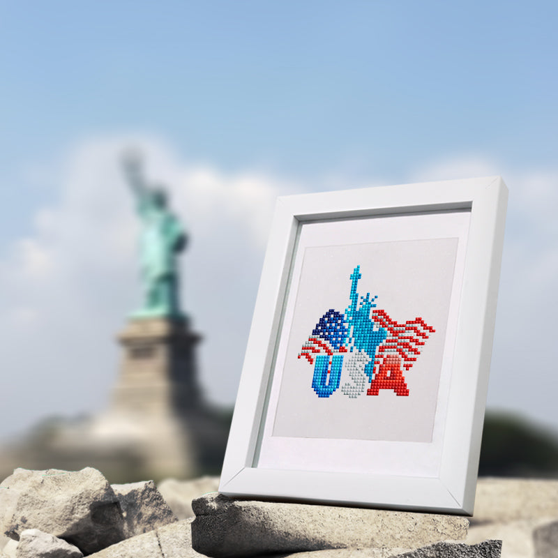 Finished DIY All American Magic diamond painting in frame, placed near the Statue of Liberty for patriotic decor