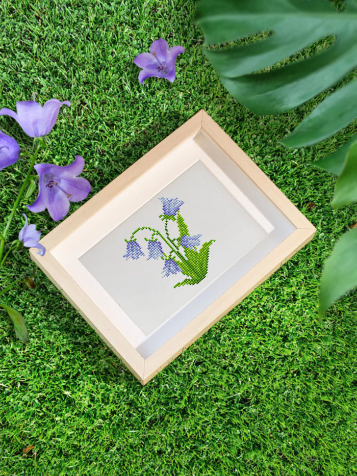 Purple and green lily of the valley flower pot diamond painting showcased outdoors, bringing calm garden energy into your space.good for beginners！
