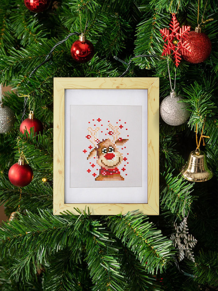 Framed mini diamond painting of a cute Christmas reindeer with antlers and red nose, displayed on a decorated Christmas tree with baubles and ornaments – festive DIY craft kit for holiday decor lovers.