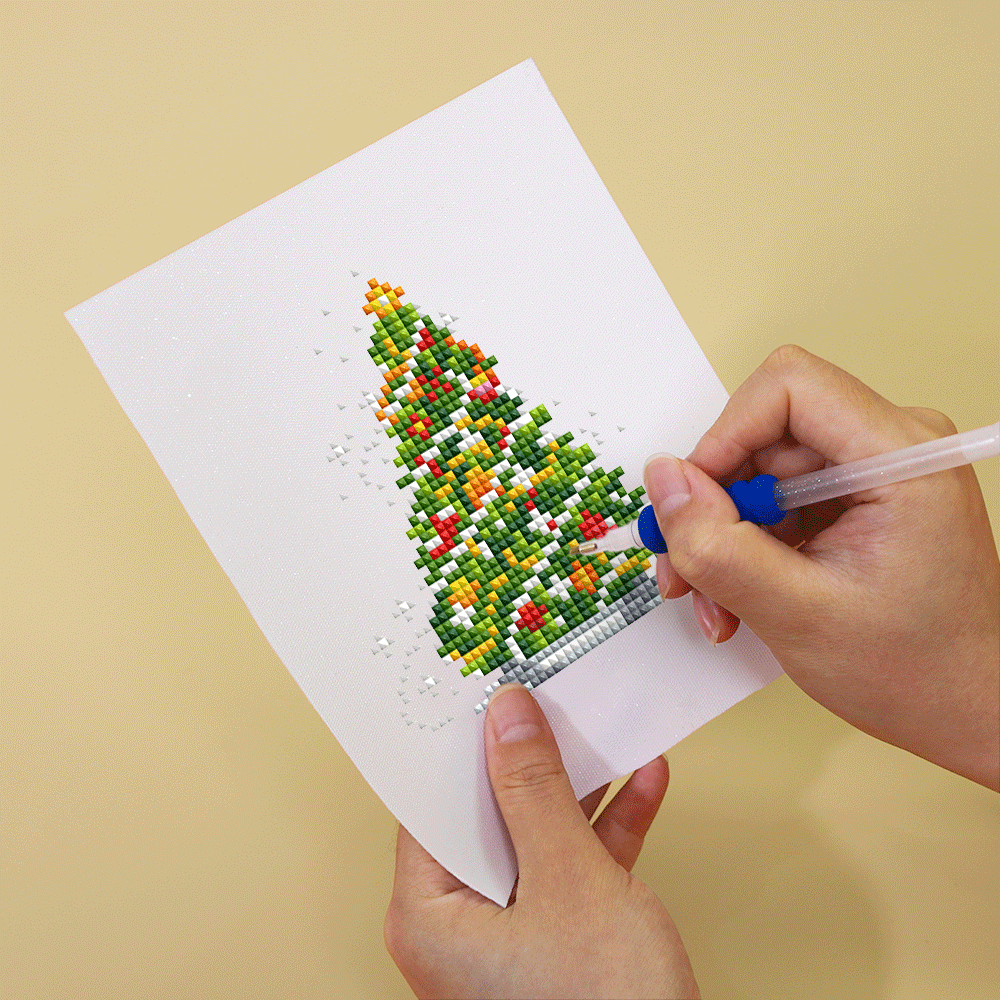 Diamond painting of a Christmas tree in progress on mini canvas. Compact and joyful design ideal for gifting and seasonal decorations.