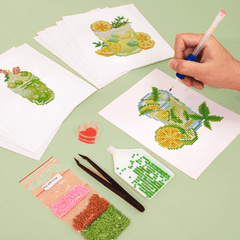 Hand placing drills on a colorful cocktail pattern canvas, showcasing the vibrant detail of this summer drink diamond painting kit.

