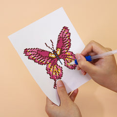 Hand placing drills on a purple butterfly diamond painting
