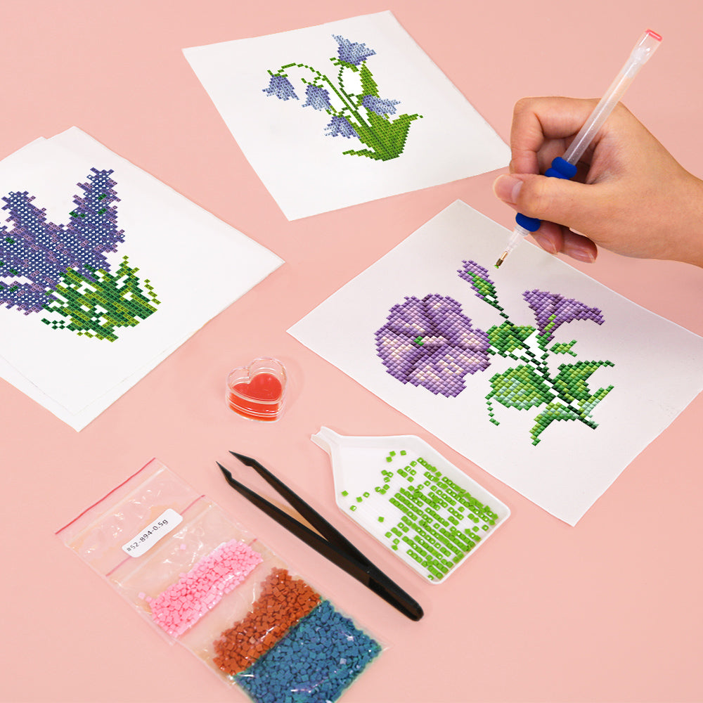 Hands working on purple and blue flower diamond painting using sticky pen – beginner-friendly and relaxing floral DIY craft