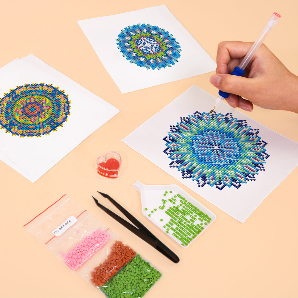 Hands working on mandala diamond painting with pen and drills，with canvas in calming blue and green tones – easy and fun craft for beginners