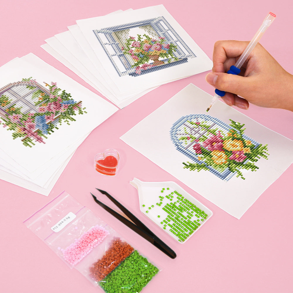 DIY floral window diamond painting kit being crafted with heart-shaped wax and tweezers.Paired with 100% resin diamonds and soft canvas, these canvases are perfect for relaxing, gifting, and decorating. Free worldwide shipping on orders over $75. Designed by a sister brand.