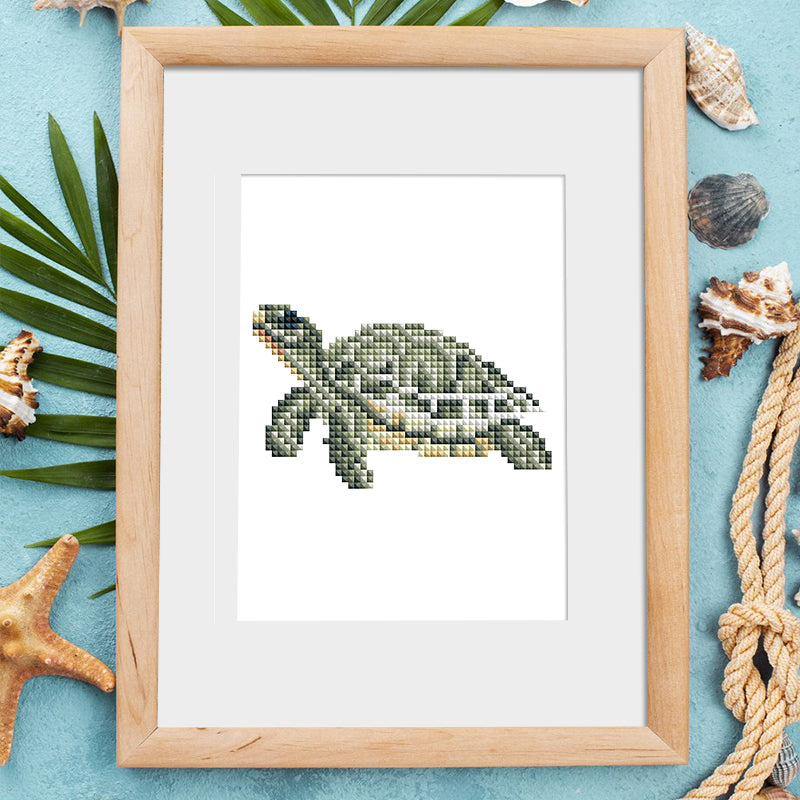 Framed sea turtle diamond painting from Ocean Whispers kit on a wooden shelf. Ocean-themed wall art for home decor.