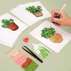 Hands working on succulent and cactus diamond canvases with DIY toolset – relaxing step-by-step activity.