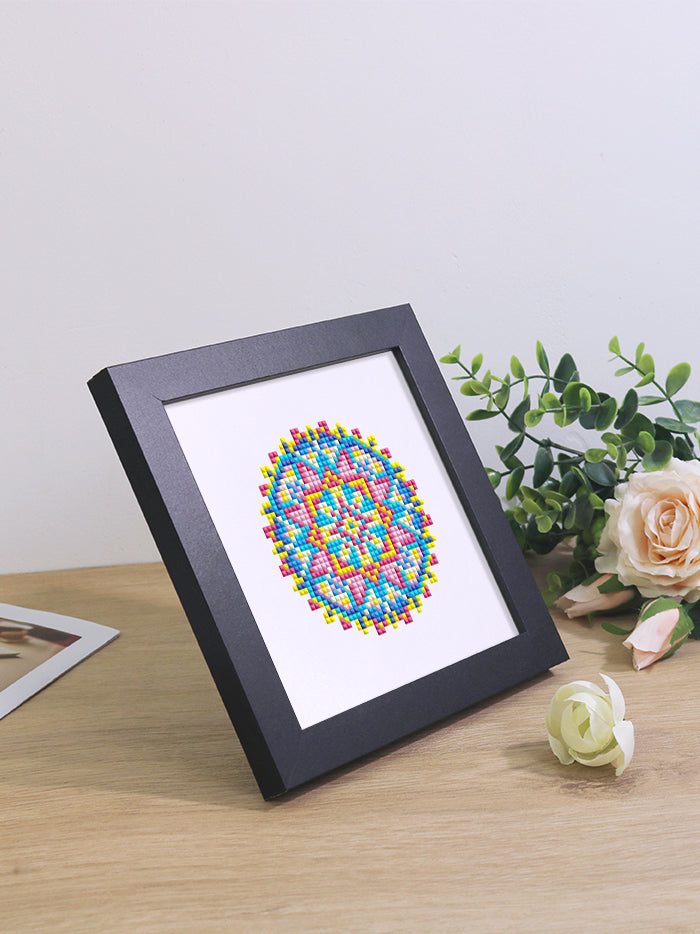 Finished mandala diamond painting art framed on a desk – vibrant colors perfect for modern home decor.
