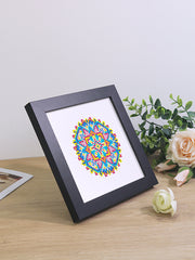 Finished mandala diamond painting art framed on a desk – vibrant colors perfect for modern home decor.
