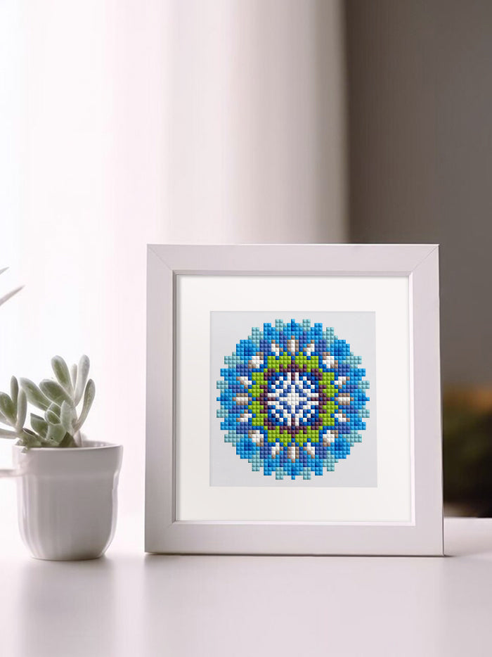 Blue and yellow mandala art framed on a table next to indoor plant – zen and aesthetic home corner.

