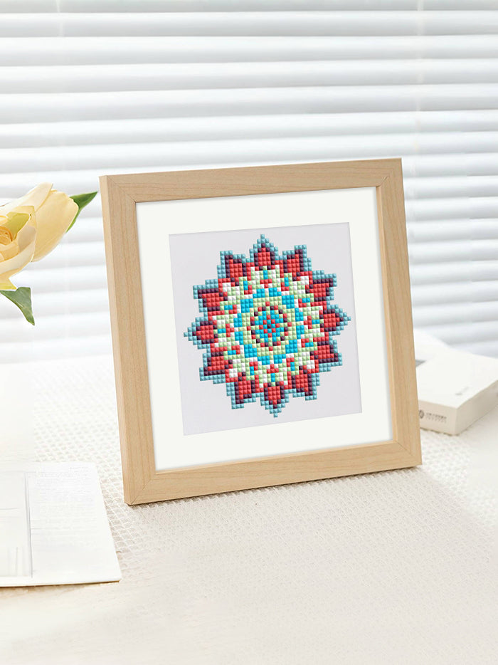 Teal and red mandala framed diamond painting displayed by the window – light-filled and peaceful setting.
