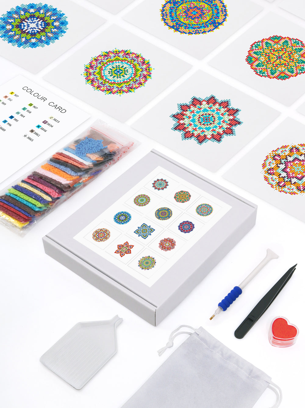 Rainbow Mandala diamond painting kit flat lay showing full set: 9 mandala canvases, drills, pen, tweezers, and color guide.
