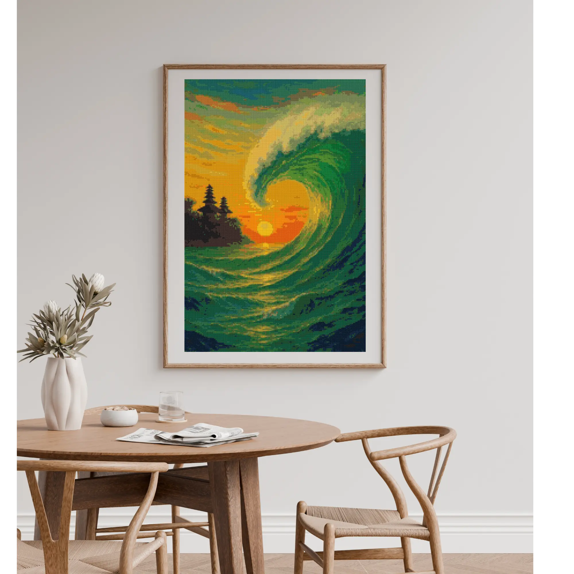 Finished diamond painting of a golden ocean wave and sunset hanging on a living room wall above a dining table.